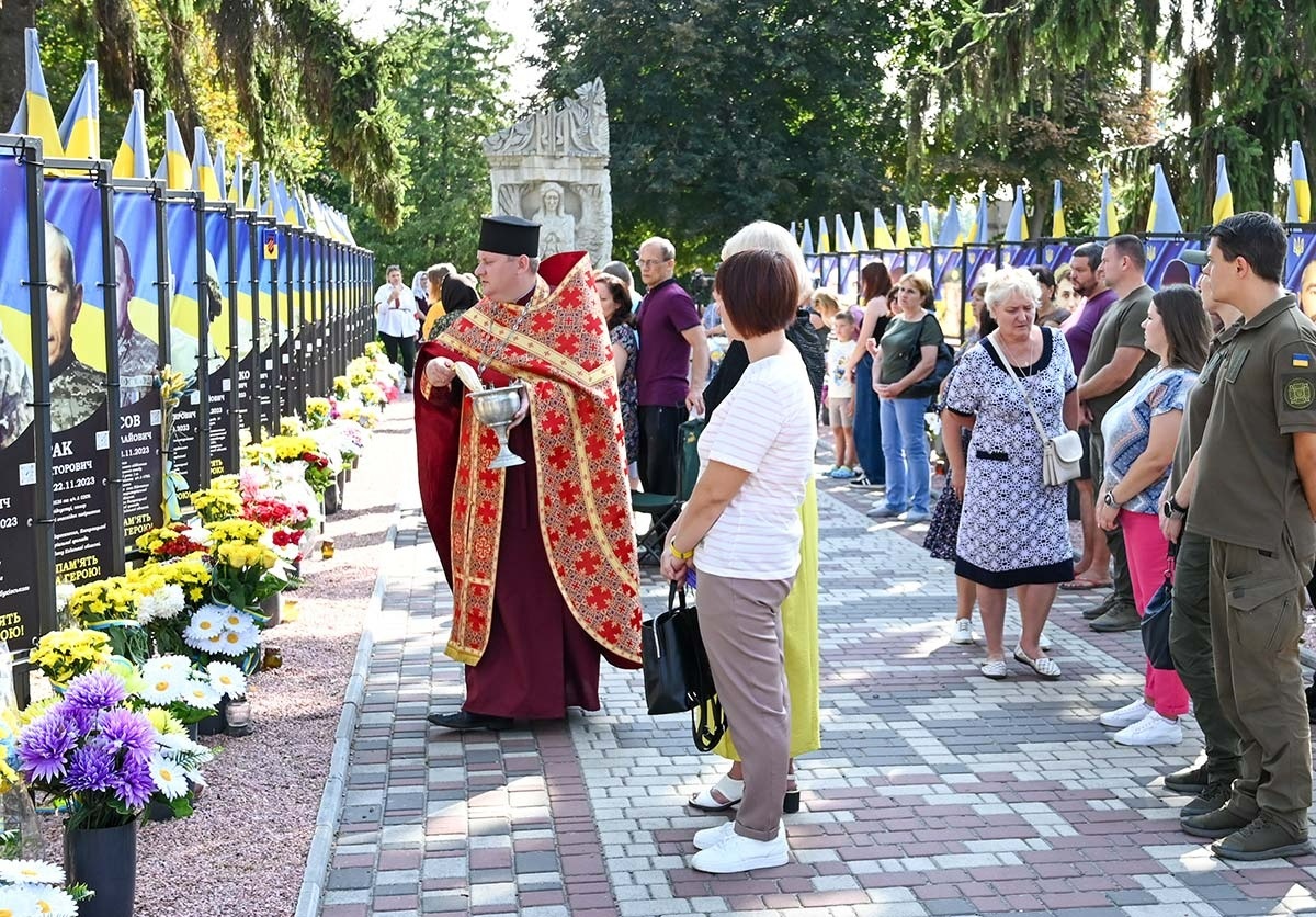 Благочинний Кагарлицького благочиння ПЦУ Юрій Литвин окроплює святою водою портрети загиблих та померлих Героїв