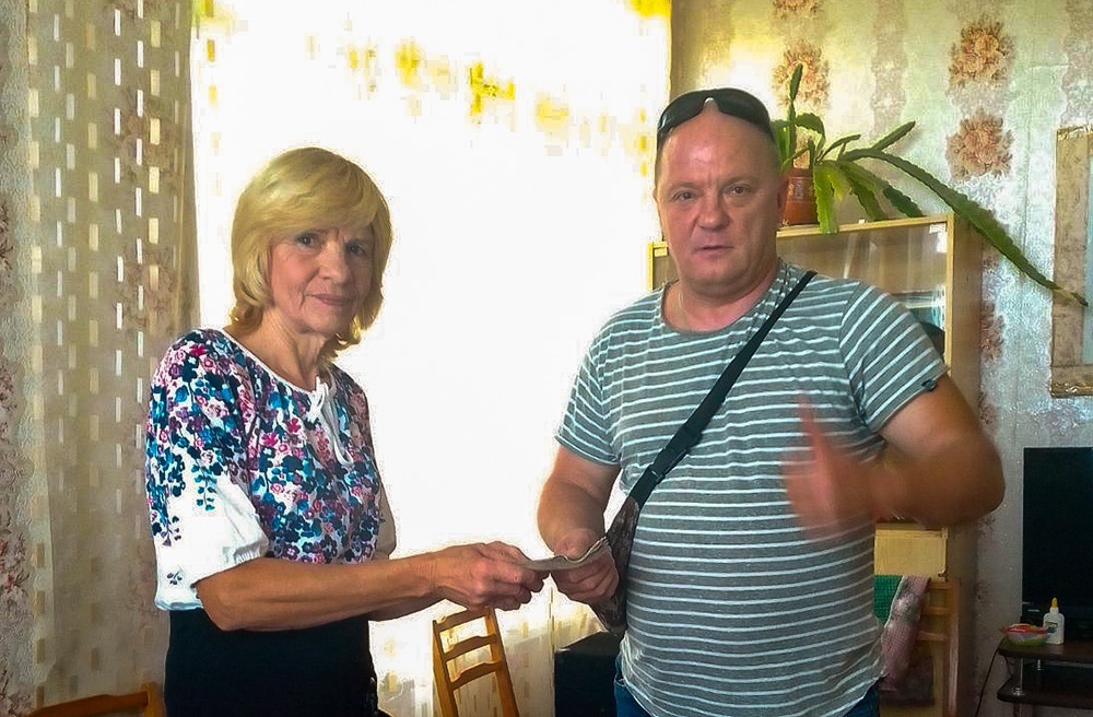 Завідувачка Зеленоярським сільским клубом на Кагарличчині Віра Янголь передає зібрані односельчанами кошти для потреб ЗСУ керівнику БО «БФ «Зерна добра» Олександру Міхайловському