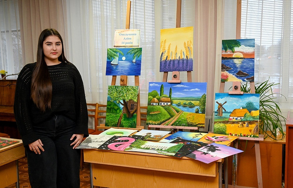 Аліна Омельченко на виставці в бібліотеці в Кагарлику біля своїх робіт 