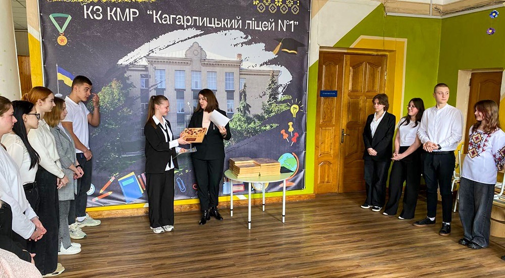 директорка Кагарлицького ліцею №1 Альона Будник вручає відзнаку Грамоту та солодкий подарунок ліцеїстці Антоніні Трохименко