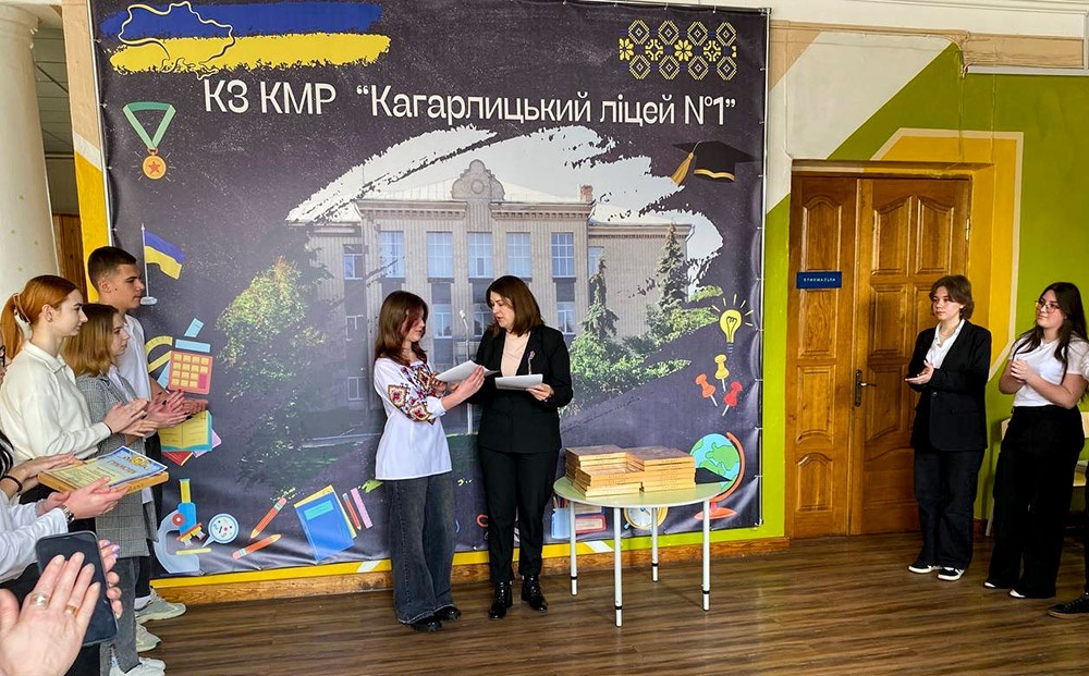 Директорка Кагарлицького ліцею №1 Альона Будник вручає відзнаку Грамоту та солодкий подарунок ліцеїстці Анні Пиндик