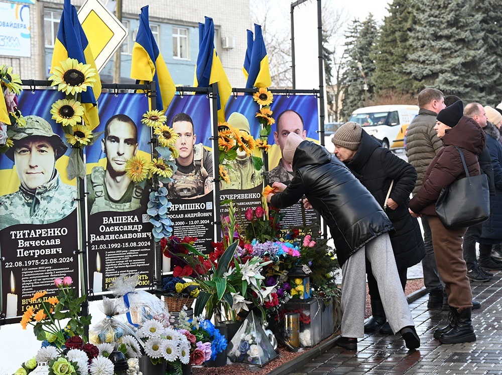 Рідні біля банеріфв загиблим воїнам в Кагарлику