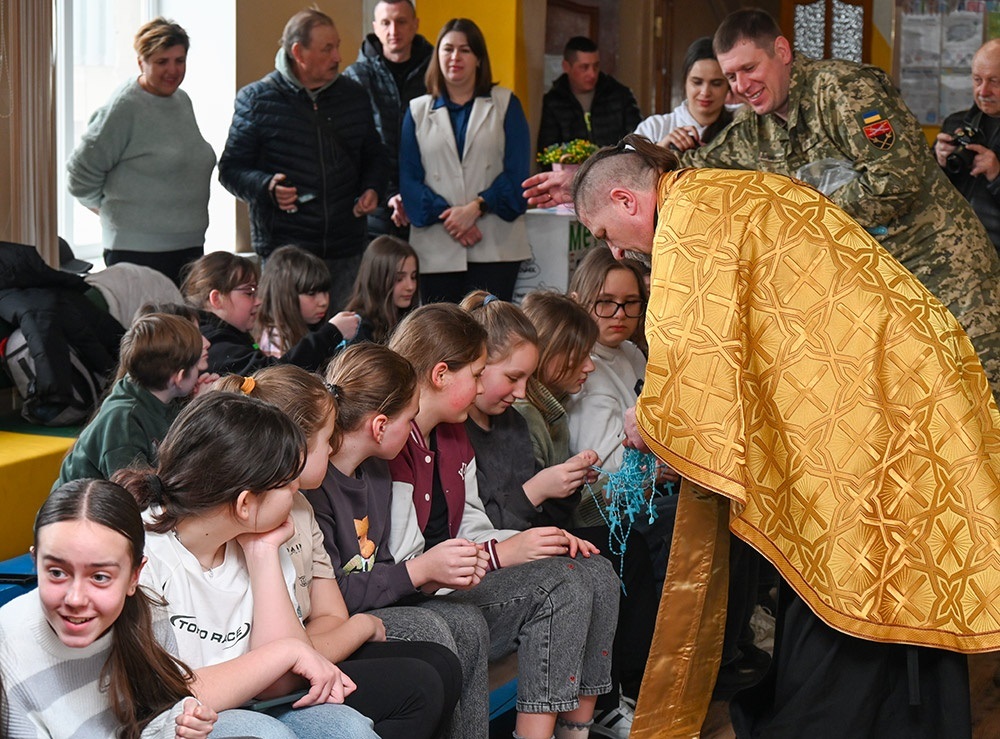 Капелан Володимир Подан роздає хрестики у навчальному закладі Кагарлика