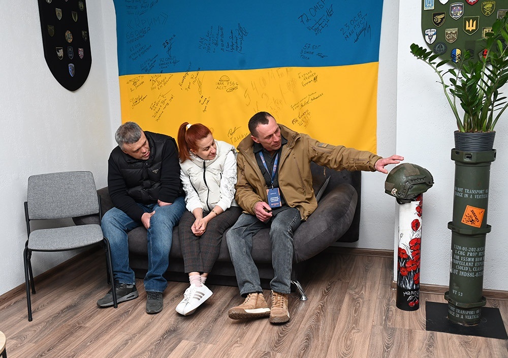 Олександо Мозговий розповідає гостям історію шолома воїна з позивним "Хрест"