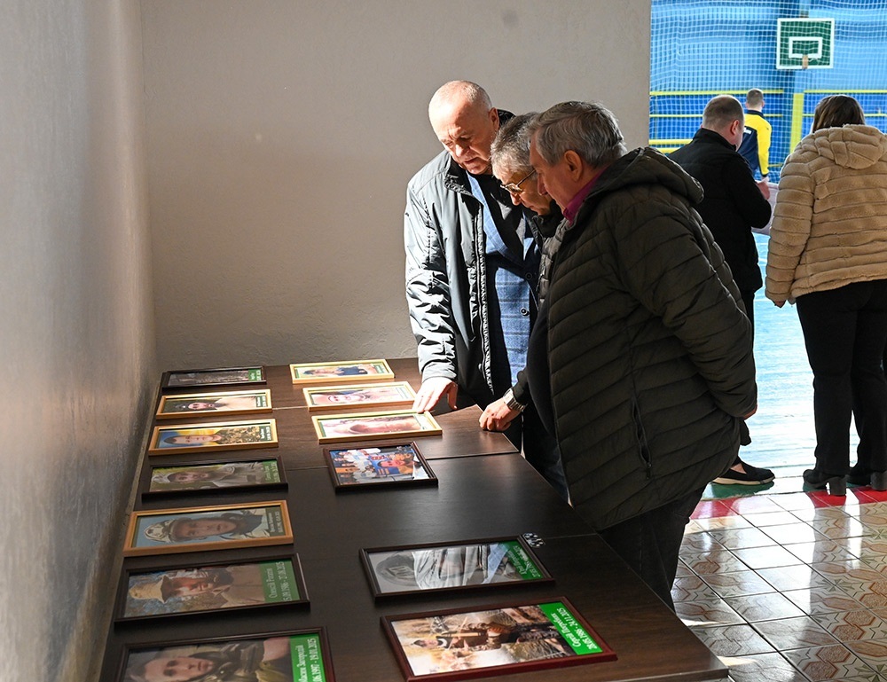 Олександр Панюта, Борис Родина та Віктор Лисенко біля портретів полеглих воїнів-земляків, які захоплювалися грою у футбол