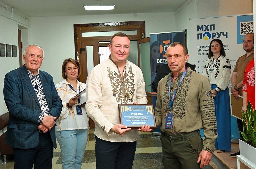 Олександр Мозговий вручає відзнаку Олександру Шпилю