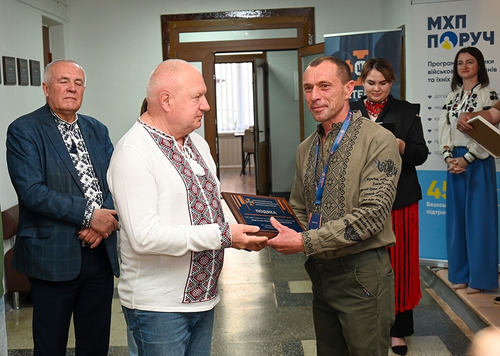 Олександр Мозговий вручає відзнаку Василю Харченку