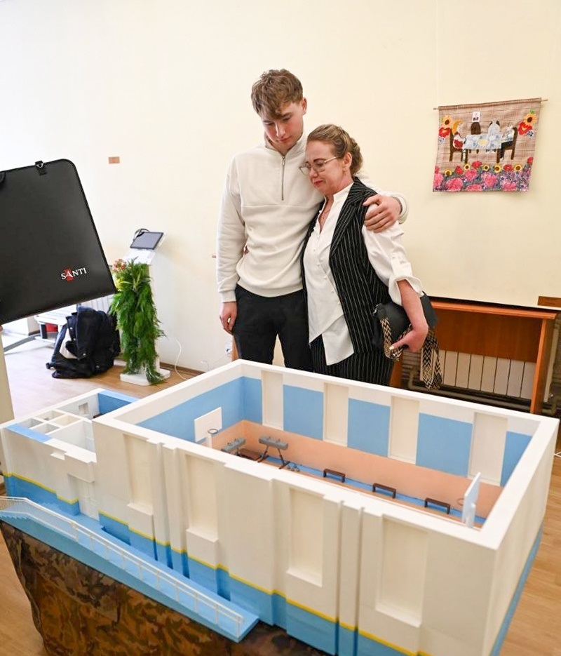 Учасниця виставки Олена Заєць зі своїм сином поруч із 3D-моделлю спортзалу імені зниклого безвісти сина-Героя Сергія Зайця