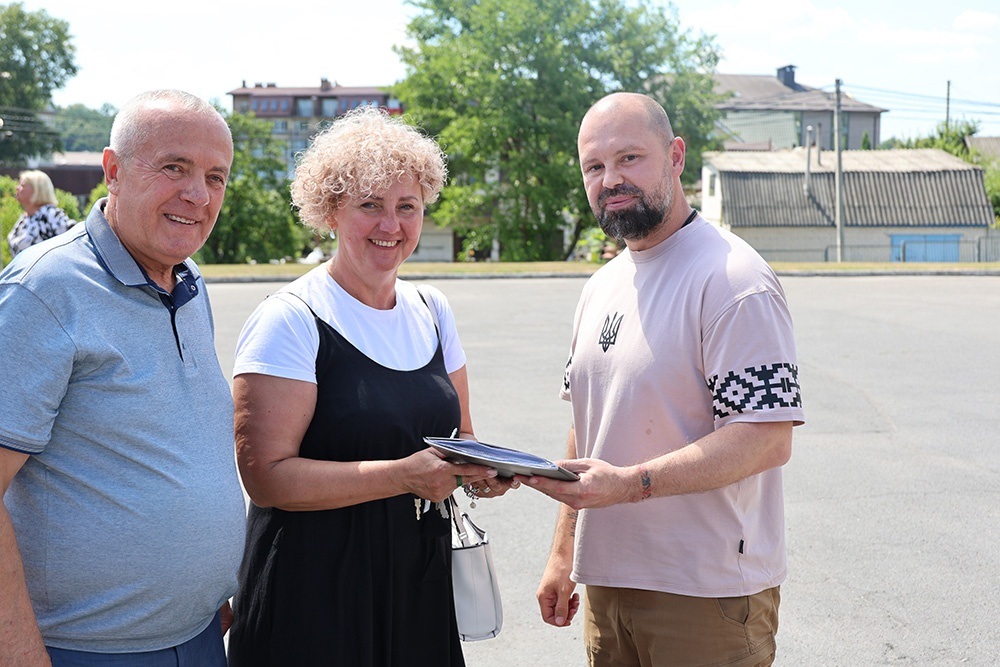 Руслан олійник вручає ключі та документи на шкільний автобус Олександру Панюті та Наталії Коваленко