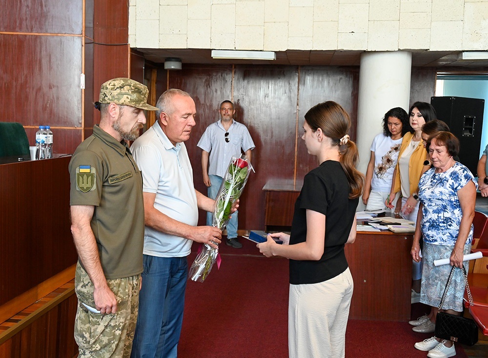 Кагарлицький міський голова Олександр панюта вручає доньці загиблого овїна Юрія Тригуба квіти